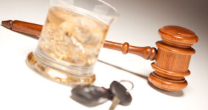 Judge’s gavel beside a glass of alcohol and car keys, symbolizing Minnesota dram shop laws and liability for drunk driving crashes.
