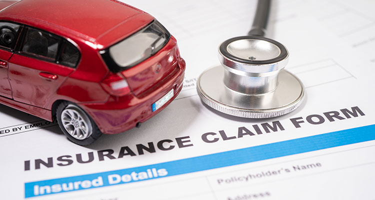 Stethoscope and toy car on an insurance claim form, illustrating medical bills and insurance claims after a Lyft accident in Minneapolis.