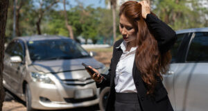 Woman calling insurance at the scene of a car accident, illustrating what injured passengers should do after a Minneapolis rideshare crash.