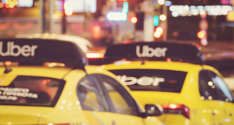 Uber-branded yellow taxis driving through city traffic at night, illustrating rideshare accidents involving Uber vehicles in Minneapolis.