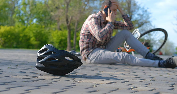 Cyclist who has fallen in a park, illustrating common bicycle-accident injuries and why injured riders may need a Minneapolis bicycle accident lawyer.