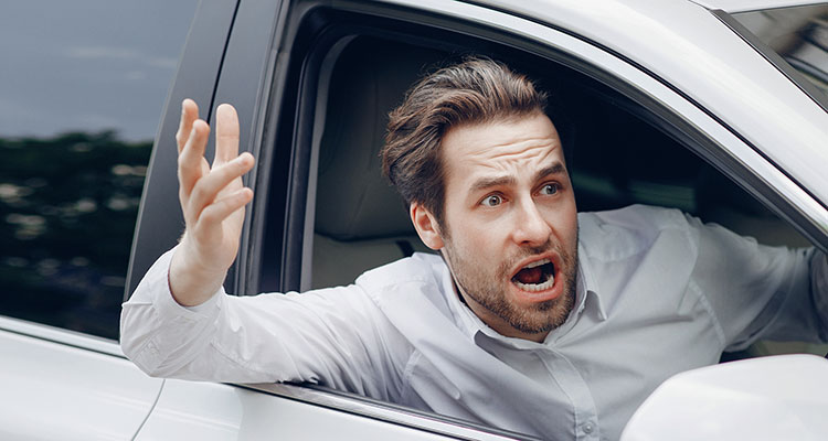 Angry driver shouting from a car in heavy traffic, illustrating Minnesota road rage behavior that can lead to intentional harm and serious car accident liability.