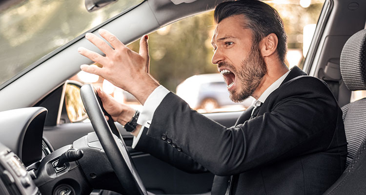 Furious driver screaming and gesturing while driving in traffic, representing road rage incidents that can cause intentional crashes and injury claims in Minnesota.